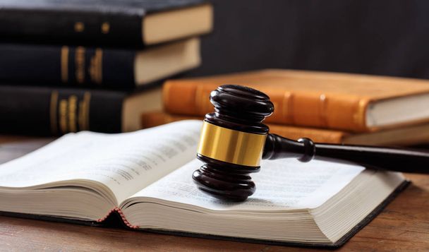Judge gavel on an open book, wooden desk, law books background - Photo, Image