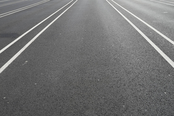 Linha branca em uma rua de asfalto preta que dirige a um ponto
 - Foto, Imagem
