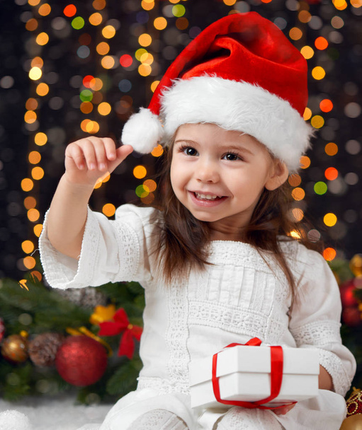 κορίτσι σε Χριστουγεννιάτικη διακόσμηση με είδη δώρων, σκούρο φόντο με φωτισμό και boke φώτα, Χειμώνας διακοπές έννοια - Φωτογραφία, εικόνα