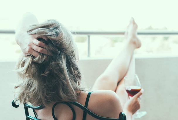 Woman enjoying her red wine on balcony. - Fotografie, Obrázek