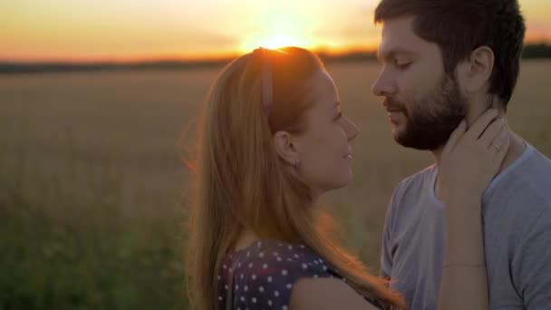 Charmant jeune couple embrassant dans le champ de blé au coucher du soleil
 - Séquence, vidéo