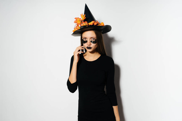Halloween Witch with patches . Beautiful young woman in witches hat and costume. Wide Halloween party art design - Foto, immagini