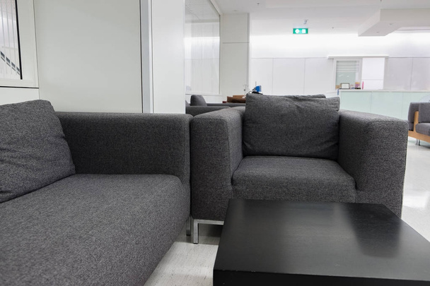 Canapé en tissu gris foncé en salle d'attente ou bureau contemporain int
 - Photo, image