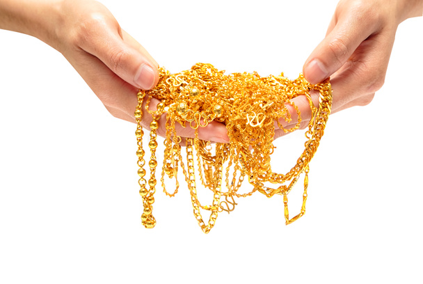Рука тримає дороге золото ювелірне намисто та браслет
 - Фото, зображення