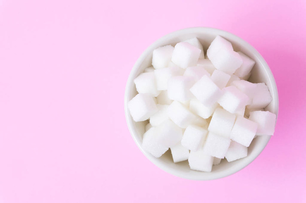 Closeup sugar cubes on bowl with pink background - Foto, immagini