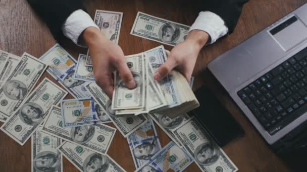 Fermez les mains d'un homme d'affaires comptant de l'argent assis à table au bureau. Concept de salaire ou de profit
. - Séquence, vidéo
