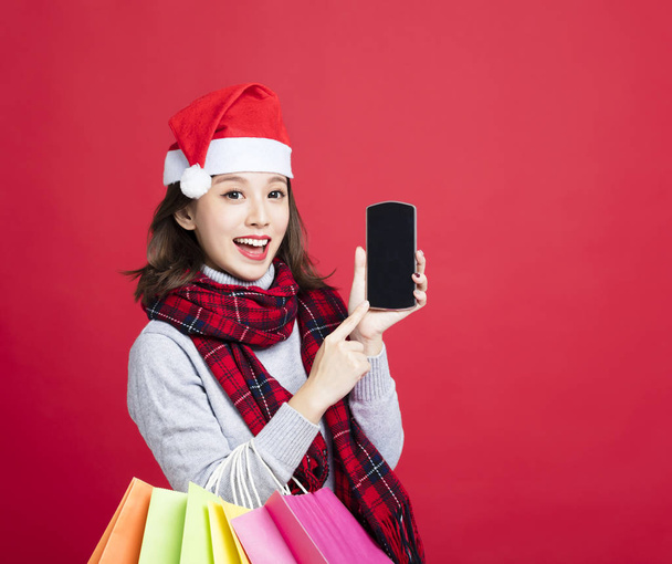 happy Woman shopping for christmas gifts by smart phone - Zdjęcie, obraz