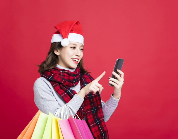 happy Woman shopping for christmas gifts by smart phone - Foto, Imagen