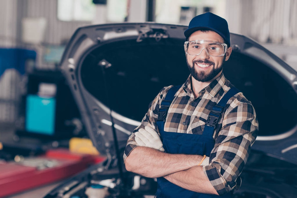 Attractive caucasian expert mechanic at work shop, standing with - Фото, изображение
