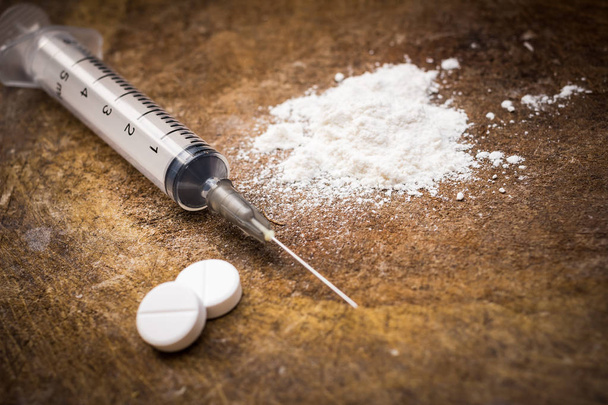 Spritze und Heroin auf Holzgrund mit Schattenrand. Drogensucht - Foto, Bild