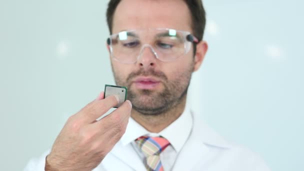Scientist in Protective Glasses Looking at Computer Chip - Footage, Video