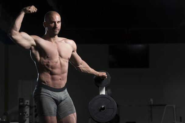 Bodybuilder Posing Double Biceps After Exercises - Фото, изображение