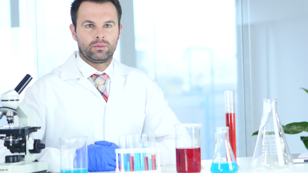 Serious Scientist Sitting in Chemical Laboratory, Microscope - Кадри, відео