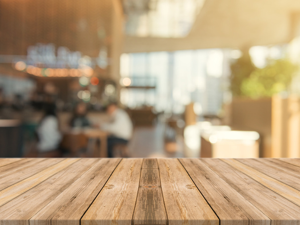 Plateau vide en bois sur fond flou. Perspective table en bois marron sur flou dans le fond du café peut être utilisé modèle pour l'affichage des produits de montage ou la conception mise en page visuelle clé. - Photo, image