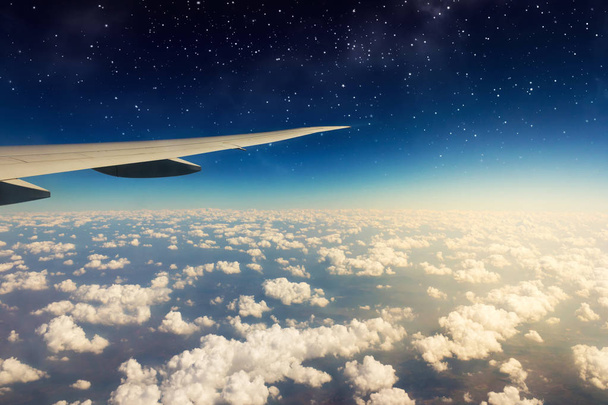 Δείτε όμορφες ηλιόλουστες σύννεφα και φτερό αεροπλάνου από το παράθυρο. - Φωτογραφία, εικόνα
