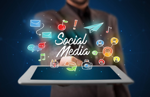 Businessman holding tablet with social media graphics - Foto, imagen