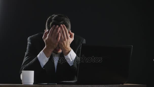 sad businessman cries while sitting at a desk in office - Footage, Video