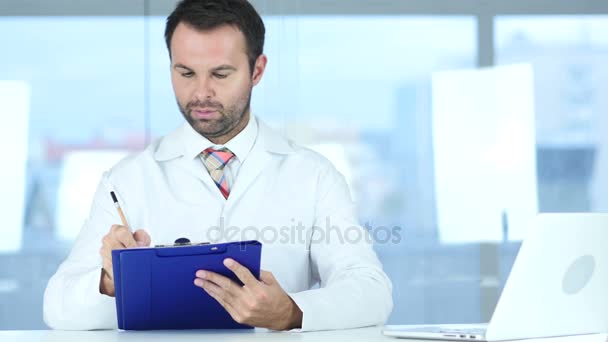 Hastanın önünde oturan, Doktor yazma tıbbi raporları - Video, Çekim