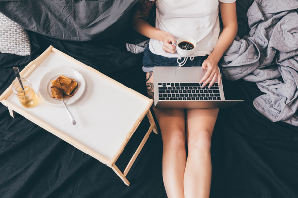 vrouw met laptop op bed - Foto, afbeelding