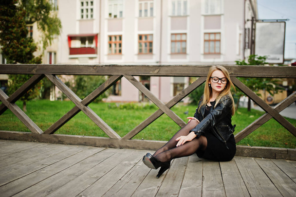 Elegant blonde girl wear on black leather jacket posing at stree - Fotó, kép