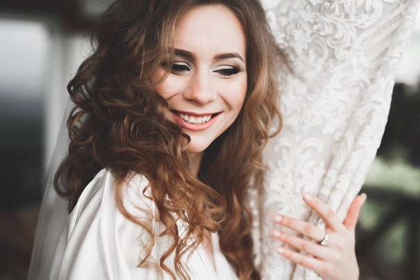 Luxury bride in white dress posing while preparing for the wedding ceremony - Foto, Imagen