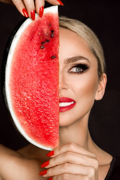 Beautiful female model with perfect face and smooth skin care, holding and eating watermelon fruit - Fotografie, Obrázek
