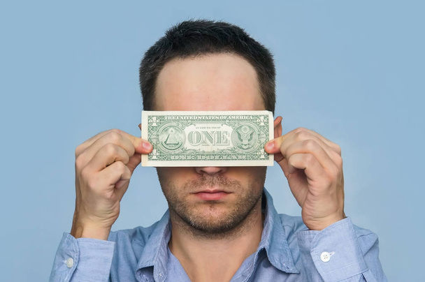 Ein Mann hält einen US-Dollar - Foto, Bild