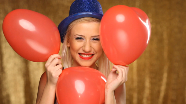 strana dívka s kloboukem modré a červené balónky - Záběry, video
