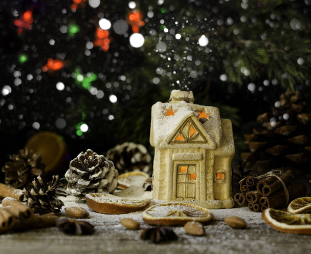 Χριστουγεννιάτικη κάρτα με μικρό παιχνίδι σπίτι και διακόσμηση σε ρουστίκ ξύλινα πίνακα, επιλεκτική εστίαση - Φωτογραφία, εικόνα