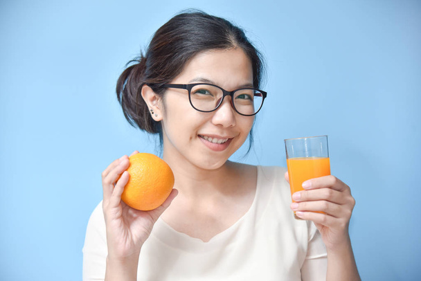 Woman holding orange with Orange juice. - Zdjęcie, obraz