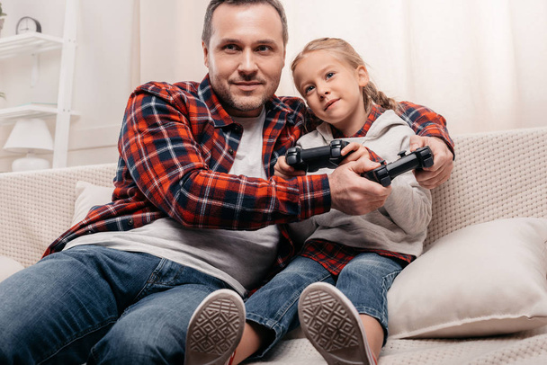 Vader en dochter spelen met joysticks - Foto, afbeelding