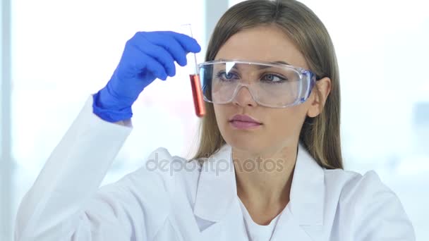 Científica investigadora, doctora mirando solución roja en tubo de ensayo
 - Imágenes, Vídeo