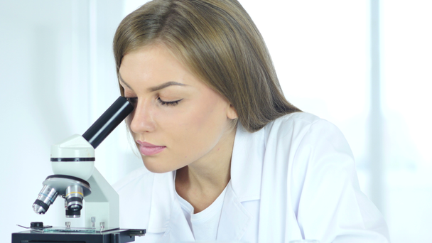 Female Chemist, Scientific Reseacher Working on Microscope in Laboratory - Кадри, відео