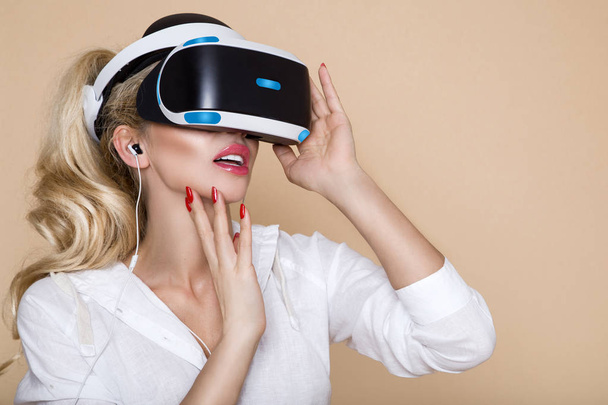 Woman with VR glasses of virtual reality. Young girl in virtual augmented reality helmet. VR headset. Future technology concept. - Photo, Image
