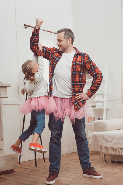 vader en dochter in roze rokken - Foto, afbeelding