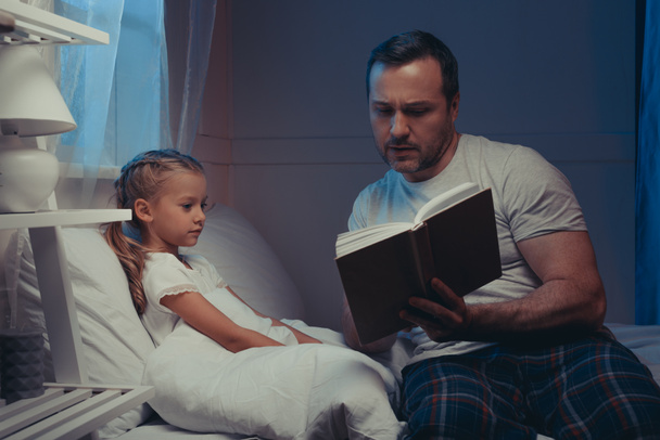 family reading book at bedtime - Φωτογραφία, εικόνα