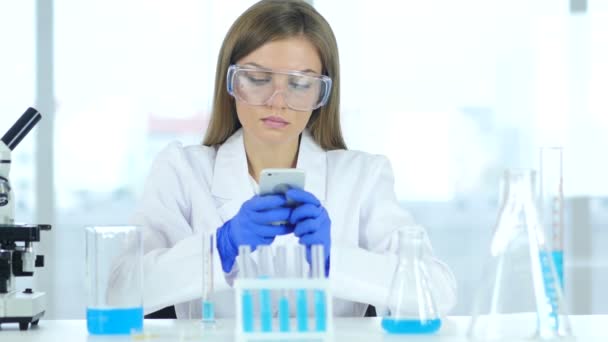 Female Scientist Using Smartphone in Laboratory - Filmagem, Vídeo