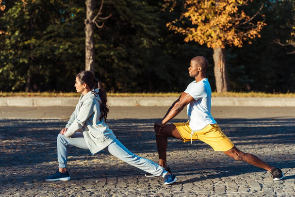 couple stretching on road - Foto, afbeelding