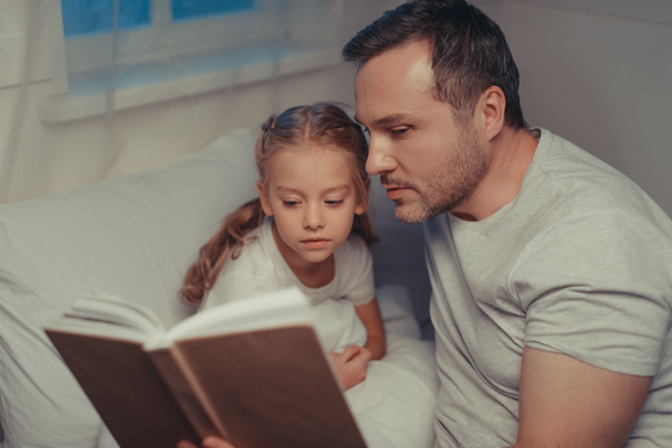family reading book at bedtime - Fotó, kép