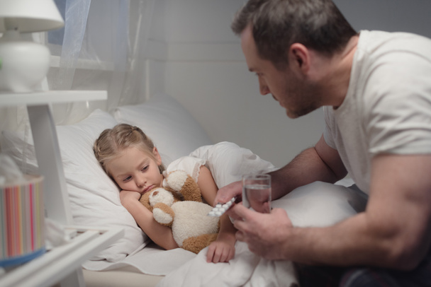 father giving pills to sick daughter - Valokuva, kuva