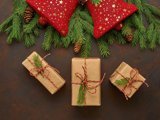 Рождественская композиция красных колоколов, ель ветвей, подарки в крафте
 - Фото, изображение