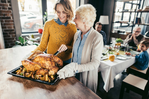 senior mother and daughter with thanksgiving turkey - 写真・画像