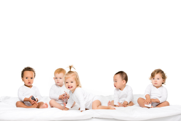 niños pequeños multiculturales con smartphones
 - Foto, Imagen