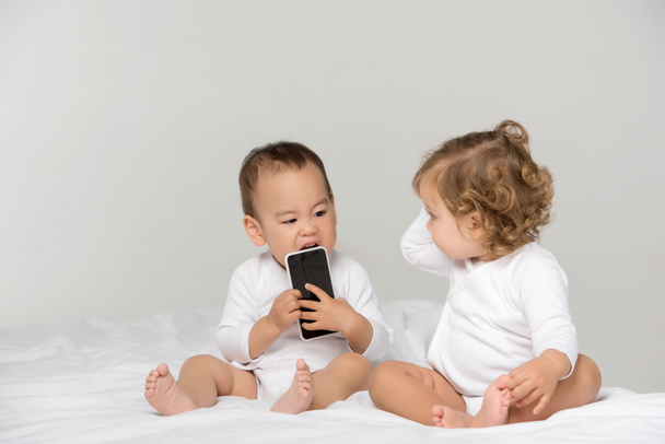 niños pequeños multiculturales con smartphone digital
 - Foto, Imagen