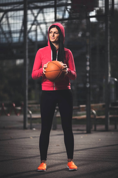 Female basketball player training outdoors on a local court - Фото, зображення