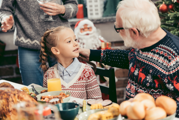 grandfather and granddaughter talking at christmas table - Foto, Imagen