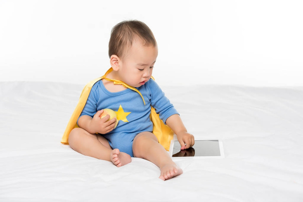 азиатский ребенок с яблоком и планшетом
 - Фото, изображение