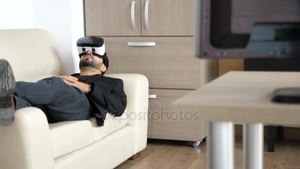 Empresario está tomando un descanso en su oficina utilizando la tecnología de auriculares VR
 - Metraje, vídeo