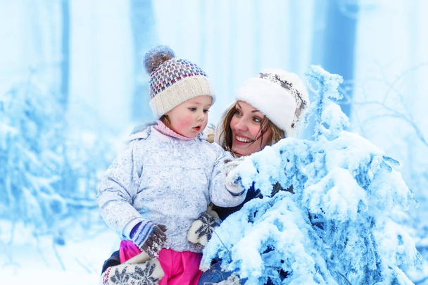 familia feliz con la madre joven y la hija del niño en un paseo de invierno al aire libre
. - Foto, imagen