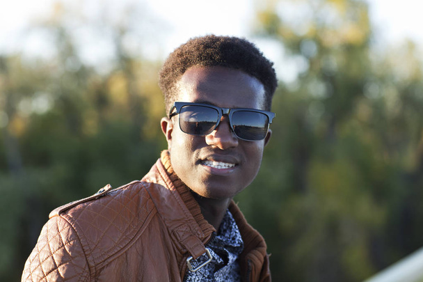 Csinos fiatal fekete férfi napszemüveg és a bőrdzseki a egy - Fotó, kép